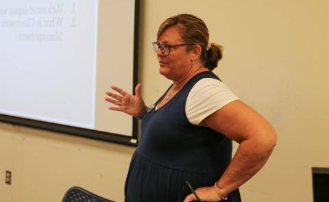 teacher standing in front of screen teaching